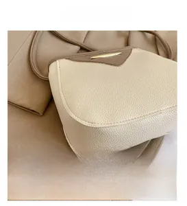 Détail du cuir grainé et des coutures précises d'un sac seau bicolore chic pour femmes