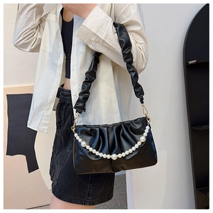 Dettaglio borsa a tracolla nera plissettata con elegante catena di perle decorative