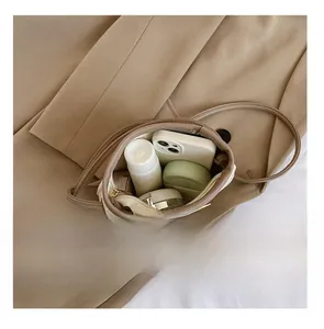 Capacité interne du sac seau en cuir beige avec téléphone et cosmétiques