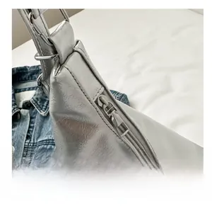 Close-up of smooth silver metal zipper and wrinkled texture on silver bucket bag