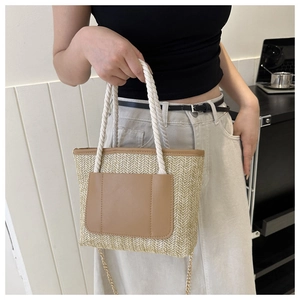 Details der Stroh-Eimertasche mit brauner Ledertasche und gewebten Baumwollgriffen