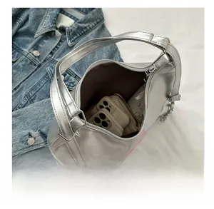 Silver wrinkled leather bag detail showing interior capacity with phones and wallet