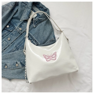 Detail of white Hobo shoulder bag featuring pink butterfly embroidery and silver chain