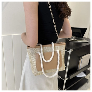 Detail der Stroh-Eimertasche mit brauner Ledertasche und Seilgriffen an einem Model