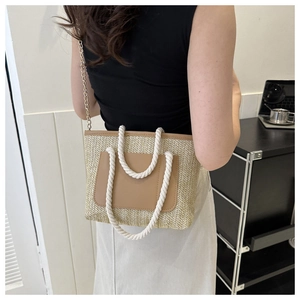 Detail der Stroh-Eimertasche mit Seilgriffen und goldener Kette an einem Model