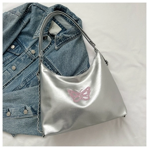Silver Y2K crescent bag detail featuring pink butterfly embroidery and metal chain