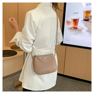 Détail du sac carré en cuir PU kaki clair avec coutures en V et barre métallique dorée
