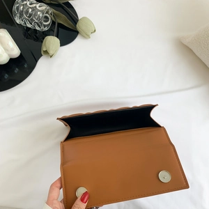 Petit sac bandoulière marron en cuir matelassé avec fermoirs argentés et décorations