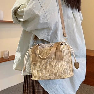 Handcrafted straw woven crossbody bag with leather straps and drawstring inner pocket