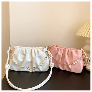 Detail of ruched cloud bags with decorative pearl and golden flower chain straps