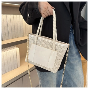 Detail der handgewebten beigen Stroh-Beuteltasche mit Ledertasche und goldener Kette