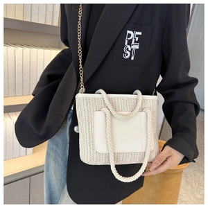 Detailaufnahme der Stroh-Eimertasche mit Ledertasche und goldener Ketten-Schulterriemen