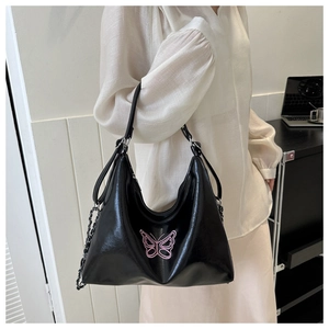 Detail of pink butterfly embroidery on a black PU leather shoulder bag with chain strap