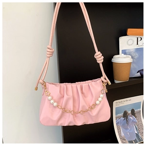 Detail of pink ruched cloud bag featuring pearl and gold floral chain with a knotted strap