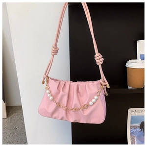 Detail of pink pleated cloud bag with elegant pearl flower chain and knot strap