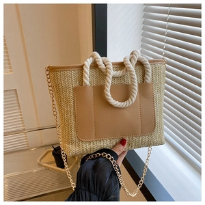 Nahaufnahme der Stroh-Eimertasche mit Seilgriff und braunem Leder-Taschendetail