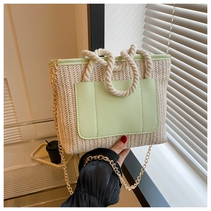 Detail der Strohtasche mit minzgrünem Lederbesatz und geflochtenem Baumwollgriff