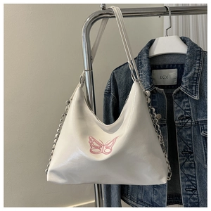 Detail der weißen Hobo-Tasche mit rosa Schmetterlingsstickerei und Silberkettenriemen