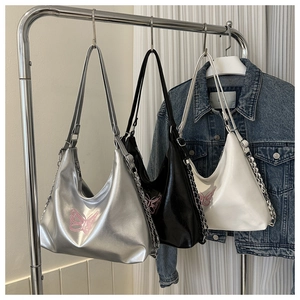 Detailed view of silver black and white hobo bags featuring butterfly embroidery and chains