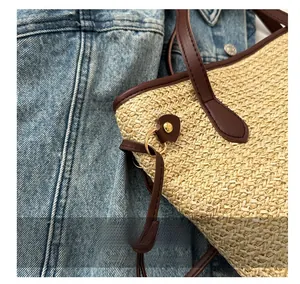 Détails d'un sac cabas en paille montrant les poignées en cuir et rivets dorés
