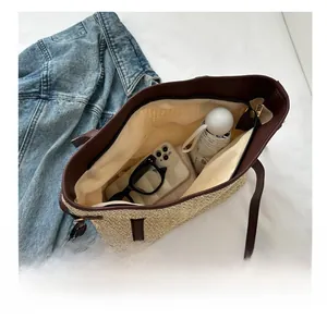 Vue de dessus du grand sac cabas en paille montrant l'intérieur spacieux et les objets
