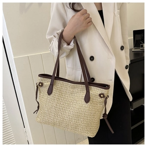 Détail du sac cabas en paille d'été avec poignées en cuir marron et cordon décoratif