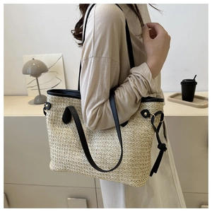 Détail du sac cabas en paille beige avec bordure en similicuir noir et fines lanières