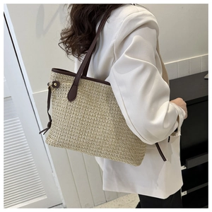 Détail du sac cabas en paille beige avec texture tissée fine et bandoulière en PU marron foncé
