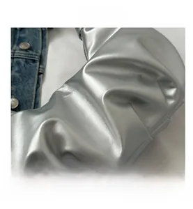 Close-up of silver pleated handbag showing metallic leather texture and cloud folds