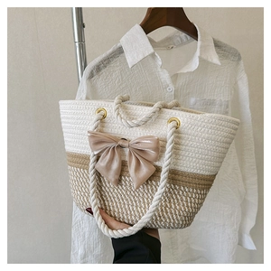 Handmade woven tote bag in cream and tan featuring a large champagne satin bow accent