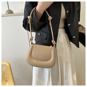 Détail du sac bandoulière en cuir kaki avec sangle nouée et garnitures dorées