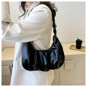Close-up of black ruched hobo bag worn with a white blazer for minimalist style