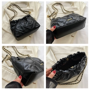Detail view showing black quilted leather, metal chain strap, and inner magnetic closure