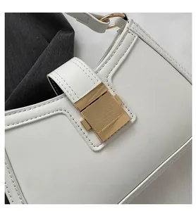 Close-up of white PU leather shoulder bag featuring a striped gold rectangular metal buckle