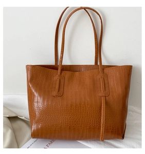 Close-up of brown crocodile pattern texture on a large capacity tote shoulder bag