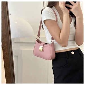 Detailed view of pink PU leather underarm bag with gold metal clasp on shoulder strap