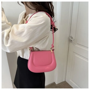 Vue détaillée du sac pois en cuir rose avec gaufrage en U et finitions métalliques dorées