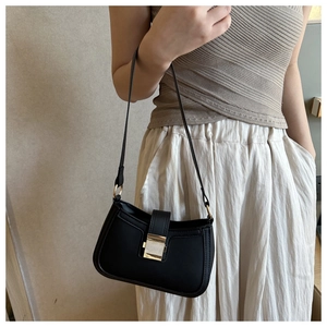 Close-up of black PU leather underarm bag featuring a metallic gold clasp closure