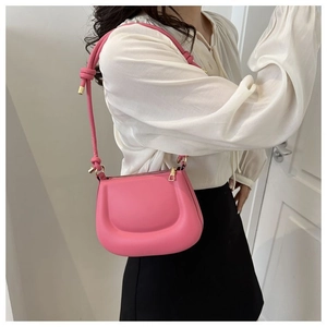 Détail du sac à épaule rose bouffant en cuir mat porté par un mannequin