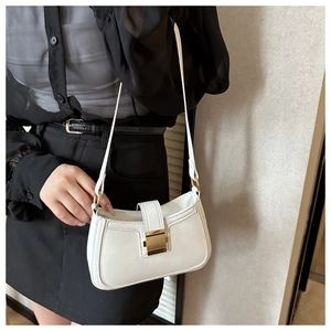 Detailed view of a white PU leather underarm bag with gold hardware and fine stitching