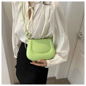 Gros plan d'un sac à bandoulière demi-lune vert fruit sur un mannequin en blanc