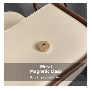 Macro detail of high-quality golden hardware magnetic buckle on beige leather crossbody bag