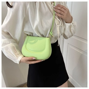 Détail du sac à bandoulière en silicone vert citron avec design de selle lisse