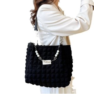 Quilted bubble tote bag in black featuring pearl chain handles and floral accents