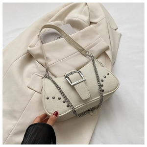 Detail of cream canvas underarm bag with silver square buckle and metal chain strap