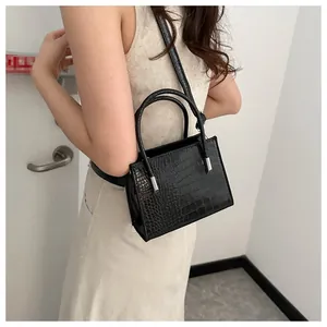 Dettaglio della mini borsa a tracolla nera coccodrillo con fibbie in metallo argento