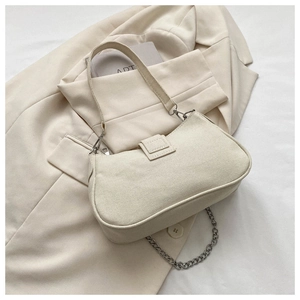 Detail view of beige canvas shoulder bag with silver chain strap on a blazer