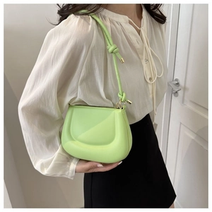 Détail du sac croissant vert citron montrant le cuir PU lisse et la sangle nouée