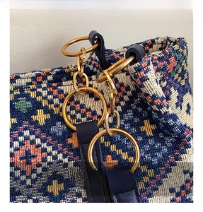 Detailed close-up of woven ethnic pattern with gold metal chain strap on tote bag