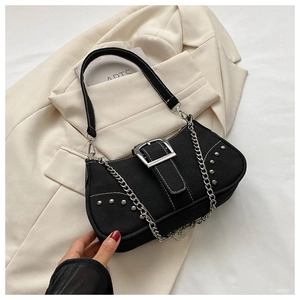 Detail of vintage black canvas shoulder bag with silver studs and metal chain decoration